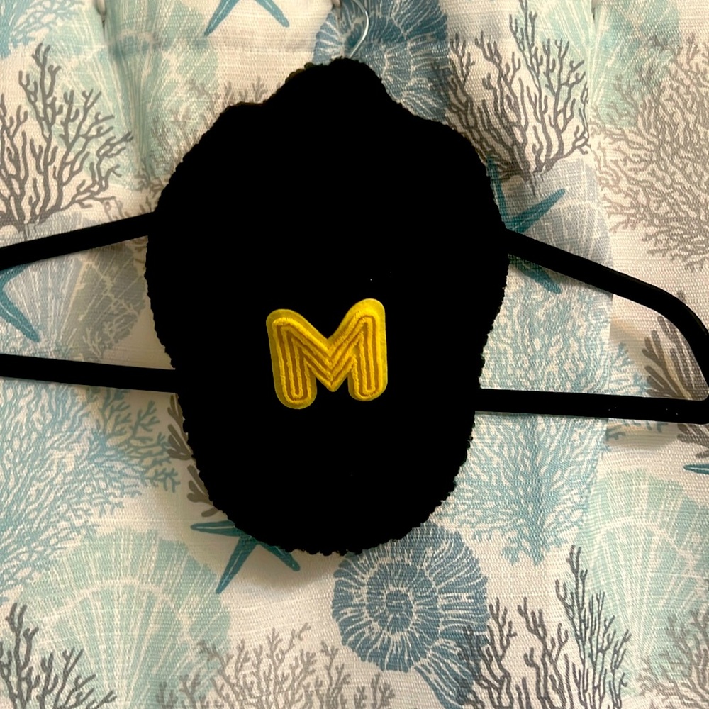 Black furry hat with M on front of it, yellow M